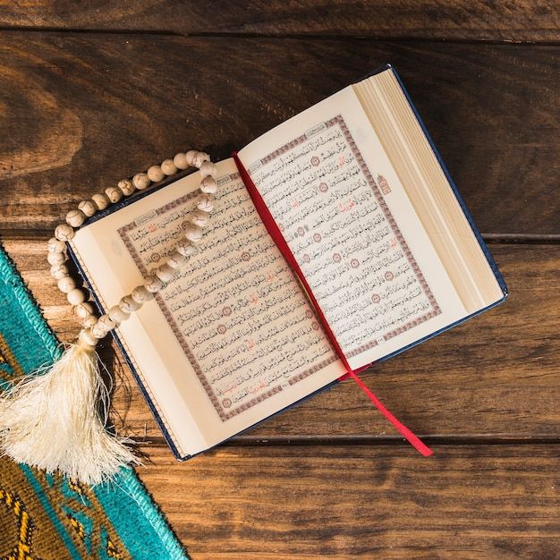 close up opened quran and beads near mat premium photo